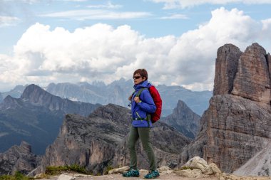 Mavi ceketli, sırt çantalı ve dağlarda yaşayan bir kız. İtalyan Dolomitleri