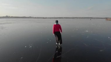 Endüstriyel bir şehrin arka planında buzda kayan bir kız.