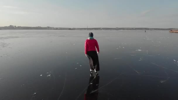 Uma Menina Patina Gelo Grande Reservatório Contra Cenário Uma Cidade — Vídeo de Stock