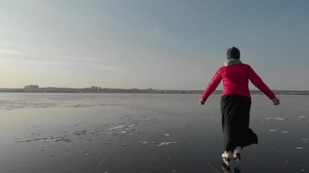 Ein Mädchen Schlittschuhläuft Auf Eis Auf Einem Großen Stausee Vor — Stockvideo