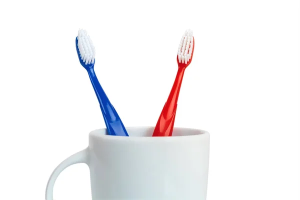 Close Van Rood Blauw Plastic Tandenborstels Witte Mok Geïsoleerd Een — Stockfoto