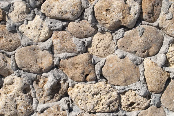 Старая бежевая каменная гранитная стена — стоковое фото