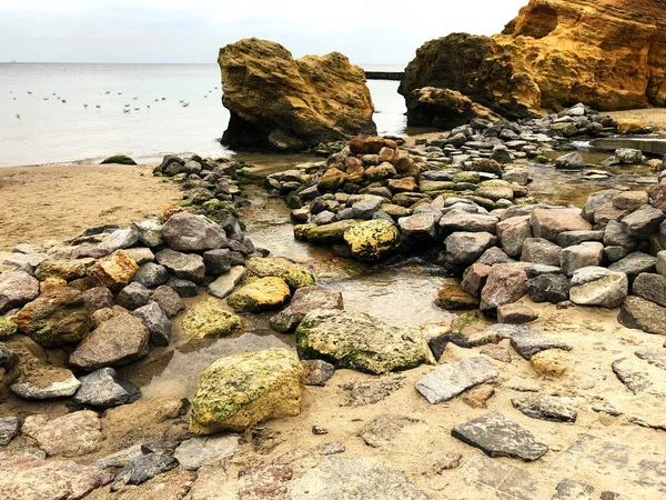 Piedras erosionadas en la playa de arena —  Fotos de Stock