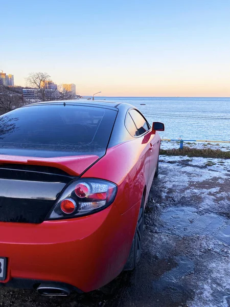 Φωτογραφία Κόκκινου Αυτοκινήτου Στο Φόντο Του Ηλιοβασιλέματος Της Θάλασσας Εικόνα Αρχείου