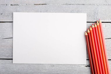 Beyaz eski ahşap arka plan üzerinde renkli kalemler. Üstten Görünüm.