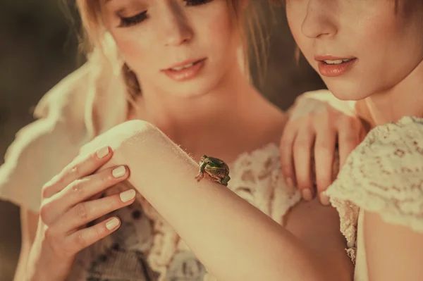 Twins holding green frog — Stock Photo, Image