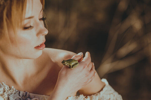 женщина держит зеленую лягушку
