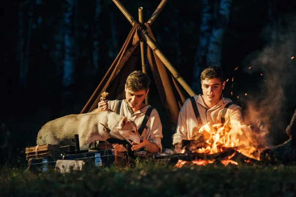 twins sitting around campfire