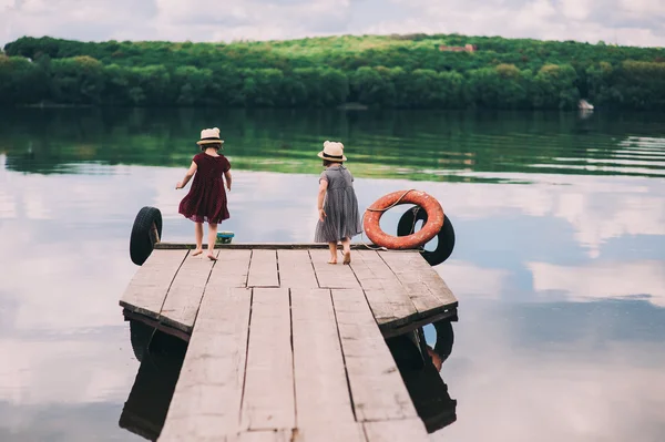 Tweelingzusjes op houten ligplaats — Stockfoto