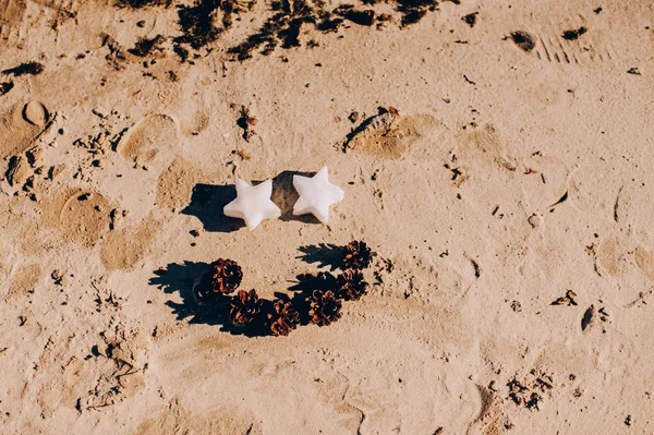 Stars and cones on sand — Stock Photo, Image