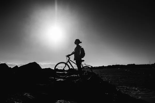 Woman with bicycle standing on shore — Stock Photo, Image