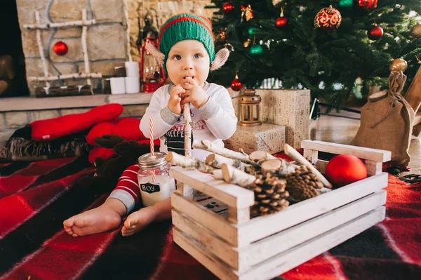 Kleine jongen zitten in de buurt van de kerstboom — Stockfoto