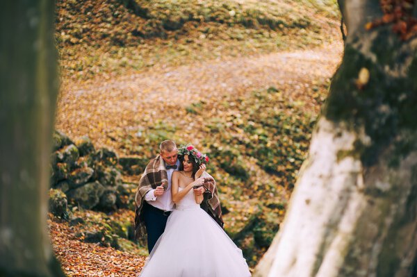 Beautiful loving couple on wedding day in autumn forest