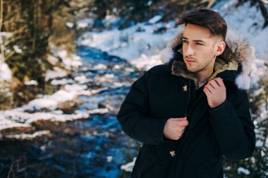 genç adam karlı ormanda poz