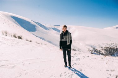 genç adam karlı dağlarda poz