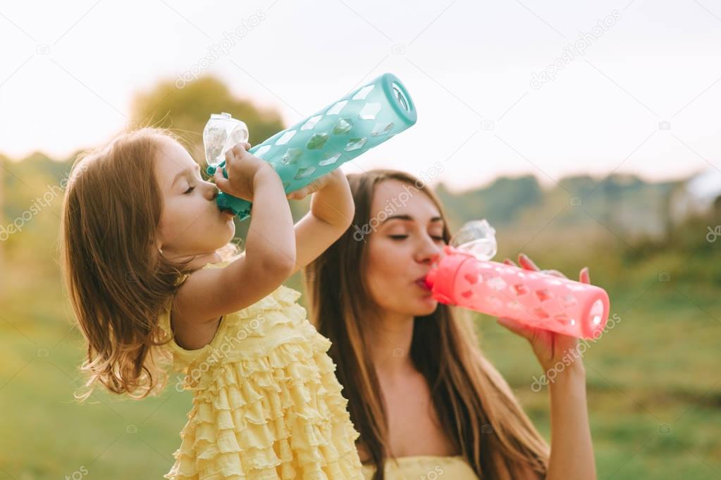 mother and daughter drinking water