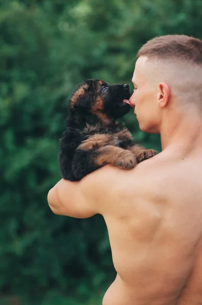 Athletic man and puppy — Stock Photo, Image