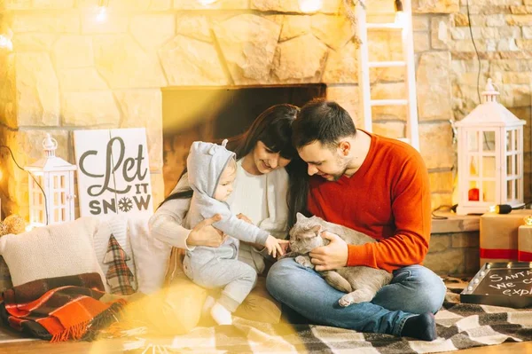 Junge Familie im weihnachtlichen Interieur — Stockfoto