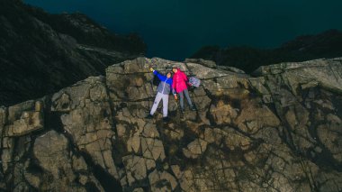 Couple in love on cliff in Norway clipart