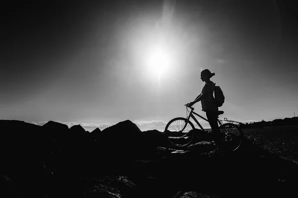 Mulher com bicicleta em pé na costa — Fotografia de Stock