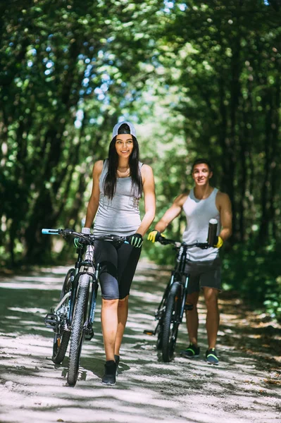 Jeune couple avec des vélos — Photo