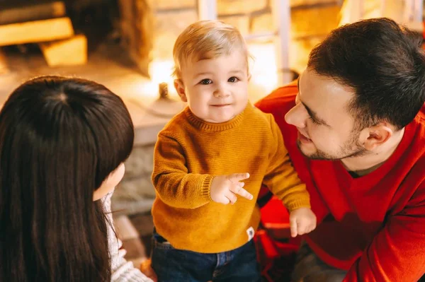 Junge Familie im weihnachtlichen Interieur — Stockfoto