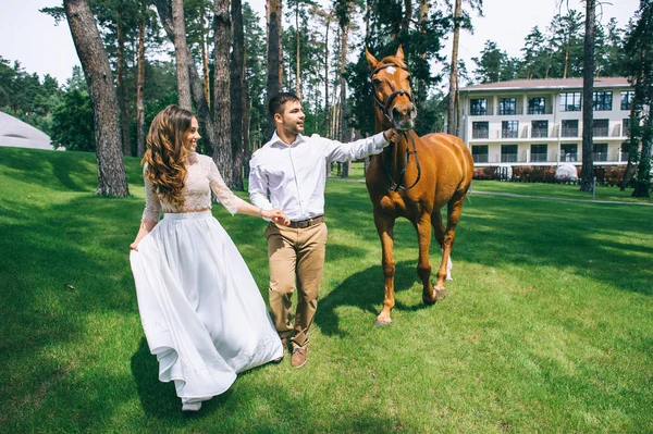 Casal de pé ao lado do cavalo — Fotografia de Stock