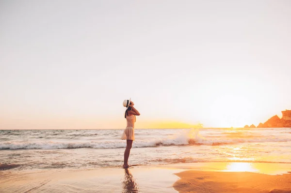 Mujer caminando a lo largo de la orilla del mar — Foto de Stock