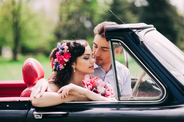 Pareja joven en coches antiguos —  Fotos de Stock