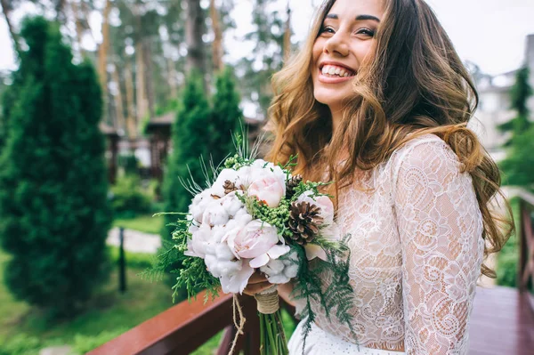 Beautiful bride with bouquet in park — Stock Photo, Image