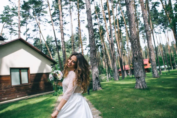 Belle mariée avec bouquet dans le parc — Photo