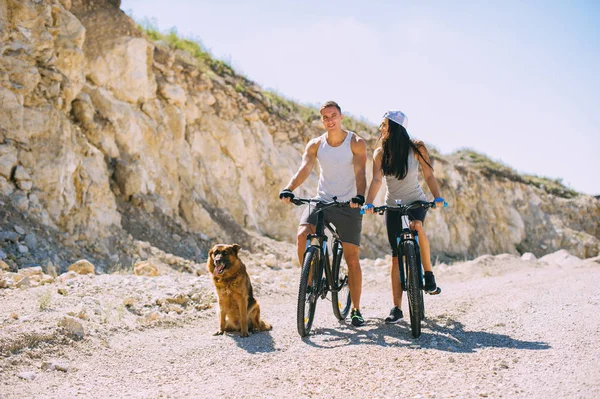 Молодые велосипедисты и собака — стоковое фото