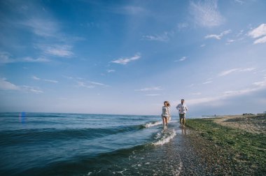 Kumsalda koşan bir çift.