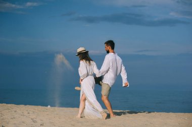 Kumsalda yürüyen çift.