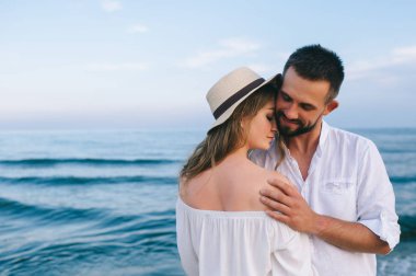 Kumsalda kucaklaşan bir çift.