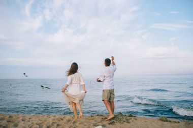 Kumsalda koşan bir çift.