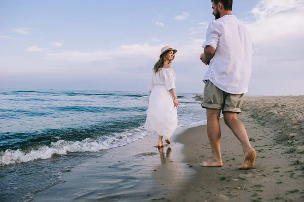 Kumsalda yürüyen çift.