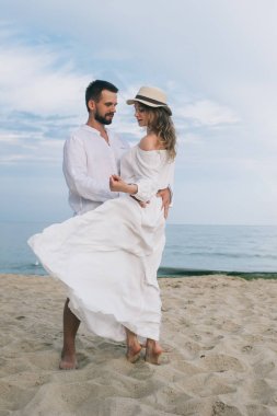 Kumsalda kucaklaşan bir çift.