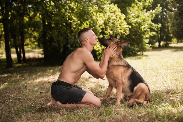 Athletic guy with a German Shepherd — Stock Photo, Image