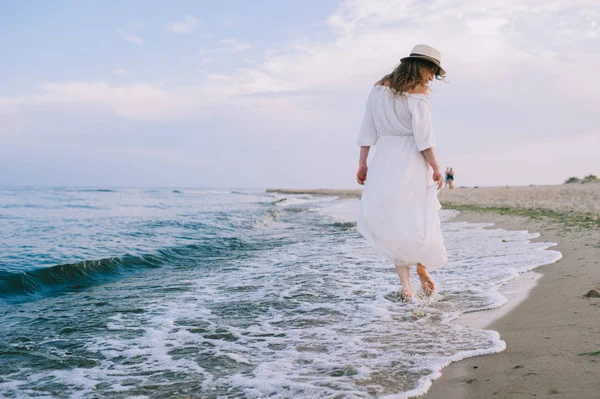 Žena kráčí po pláži — Stock fotografie
