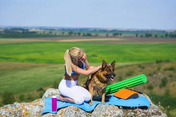 Girl practices yoga with dog — Stock Photo, Image