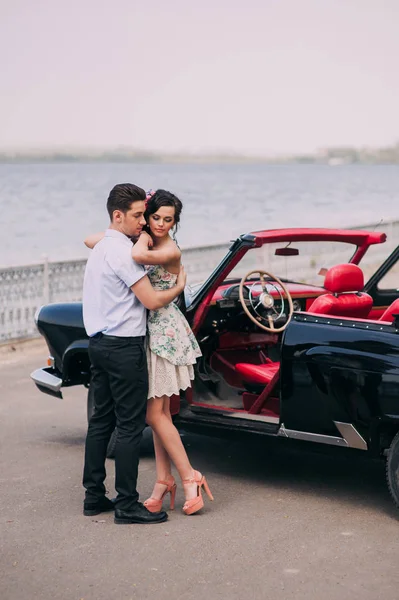 Fille avec un gars près de voiture rétro — Photo