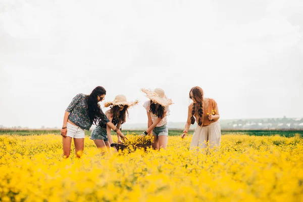 Flickor i ett fält av gula blommor — Stockfoto