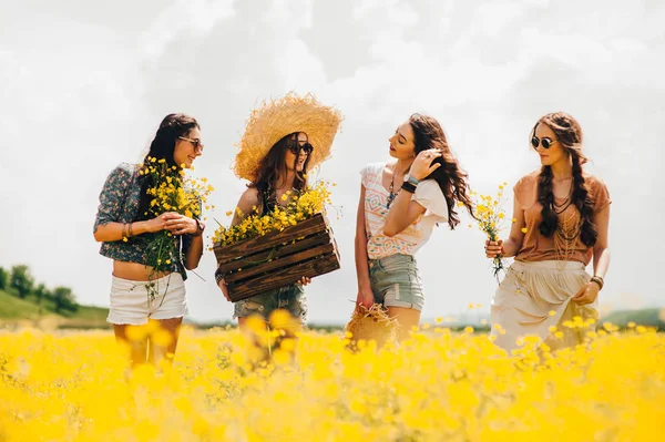 Flickor i ett fält av gula blommor — Stockfoto