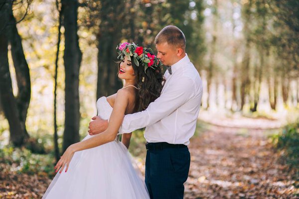 Happy bride and groom in the autumn forest