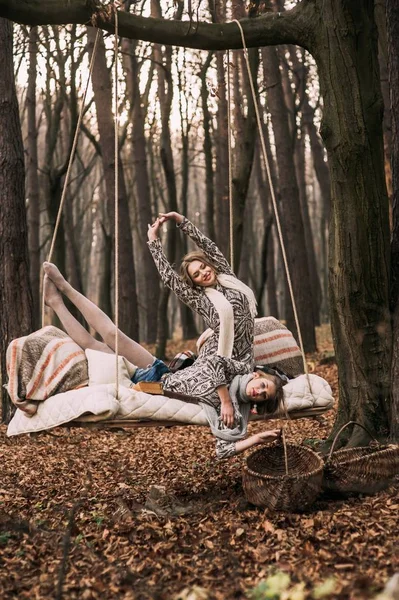 Hermana gemela en swing en el bosque —  Fotos de Stock