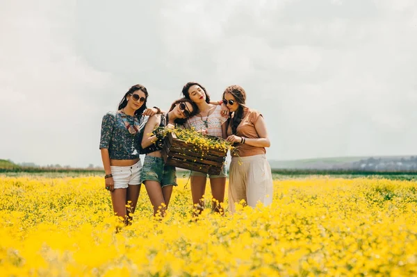 Girls in a field of yellow flowers — Stock Photo, Image