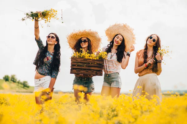 Meisjes op een gebied van gele bloemen — Stockfoto