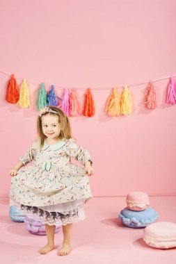 Pembe elbise poz içinde sevimli küçük kız