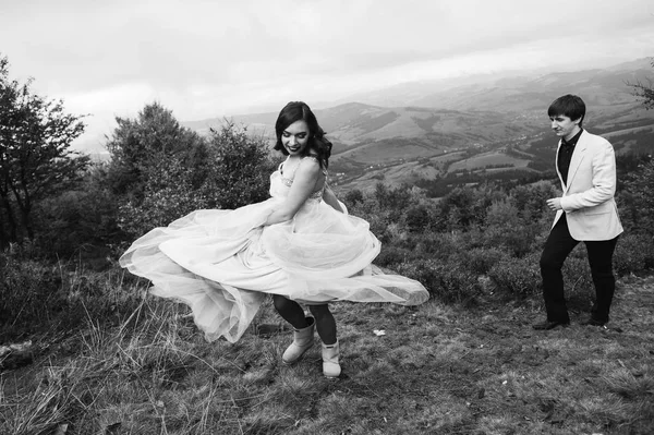 Μονόχρωμη Φωτογραφία Του Νιόπαντρο Ζευγάρι Έχει Διασκέδαση Στα Βουνά — Φωτογραφία Αρχείου